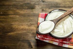 Natural yogurt in a bowl with a spoon. photo