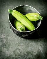 Fresh zucchini in the old pot. photo