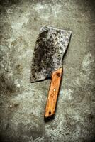 Old hatchet for cutting. On stone background. photo