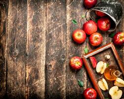 Apple cider vinegar, red apples in the old tray . photo