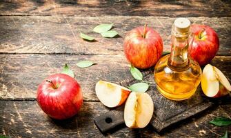 Apple cider vinegar, red apples . photo