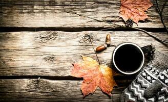 otoño estilo. un taza de caliente café con mitones. foto