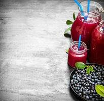 Blueberries and blueberry juice. On black wooden background. photo