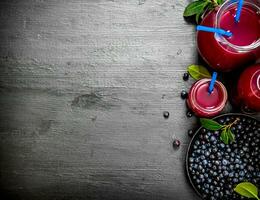 Blueberries and blueberry juice. On black wooden background. photo