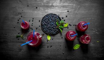 Blueberries and blueberry juice. On black wooden background. photo