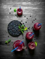Blueberries and blueberry juice. On black wooden background. photo