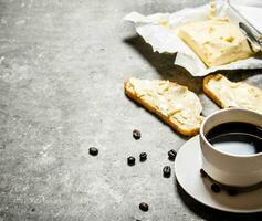 taza de café y sándwiches en Roca mesa. foto