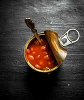 Red tinned beans. On black wooden background. photo