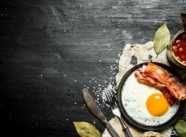 Breakfast in the morning. Beans with fried egg and bacon. photo