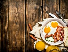 Fried bacon with eggs and orange juice. photo