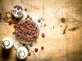 sano alimento. chocolate cereal con frambuesas y leche. foto