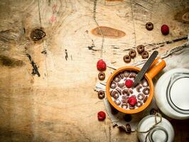 Healthy food. Chocolate cereal with raspberries and milk. photo