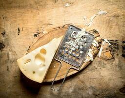 piece of cheese and the grater on the Board. photo