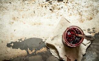 Cherry jam in jar with spoon. photo