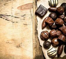 Different chocolates on old paper. photo
