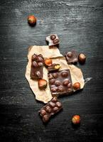 The chunks of chocolate with whole hazelnuts . photo