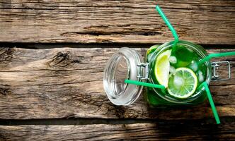 Mojito in a jar with 4 tubes on a wooden table. photo