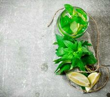 Cocktail glass - mint, ice, rum and lime on a stone pedestal . photo