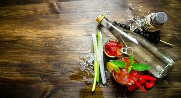 Making a cocktail with vodka, tomato paste and other ingredients on wooden background . Free space for text. photo