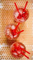 Three red cocktail with ice and straws . photo