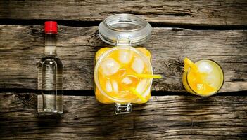 Orange cocktail with vodka and ice on a wooden table. photo