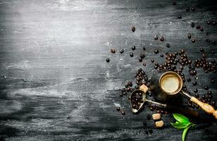 Coffee pot with coffee beans, cane sugar and fresh leaves. photo