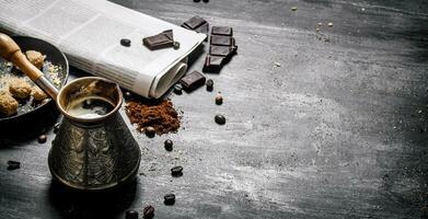 elaborada café maceta con Fresco periódico y amargo chocolate. foto