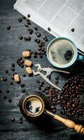 Coffee pot and a newspaper with roasted coffee beans around. photo