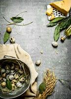 Quail eggs in a pot and cheese with spices. photo