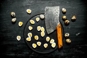 Halves of boiled quail eggs with an axe. photo