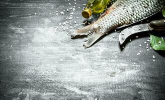 Fish with an old carving knife and olive oil. photo