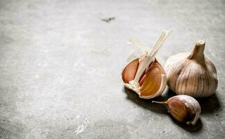 Fresh fragrant garlic on stone background. photo