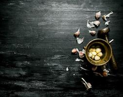 Garlic background. Fresh garlic and a mortar with pestle. photo