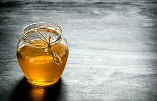 jar of natural honey . On black rustic table. photo