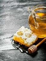 Honey background. Natural honey comb and a glass jar. photo
