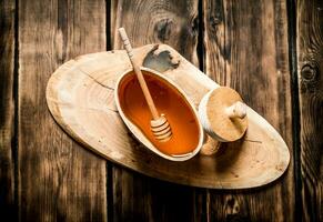 Natural honey in wooden barrel with spoon. photo