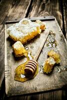 Natural honey in honeycombs with a spoon on the Board. photo