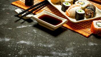 The rolls and sushi with soy sauce on bamboo stand. photo