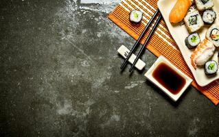 The rolls and sushi with soy sauce on bamboo stand. photo