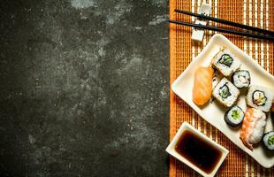 The rolls and sushi with soy sauce on bamboo stand. photo