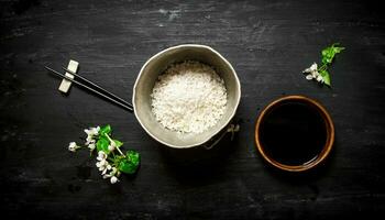 Rice in an old pot and soy sauce. photo