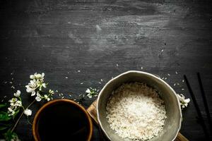 Rice in an old pot and soy sauce. photo