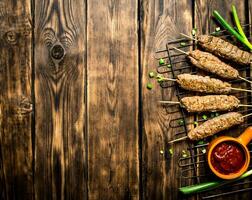 Kebab with tomato sauce and green onions. photo
