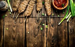 brocheta con tomate salsa y verde cebollas. foto