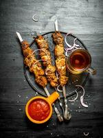 Shish kebab on skewers with beer and tomato sauce. photo