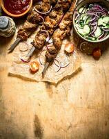 Fresh salad with Shish kebab on skewers. photo