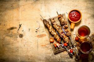 Beer with pork Shish kebab and tomatoes. photo