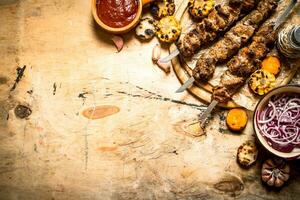 Shish kebab with salad, vegetables and beer. photo