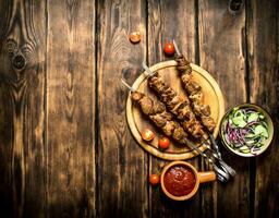 Kebab with fresh salad of cucumbers and onions. photo