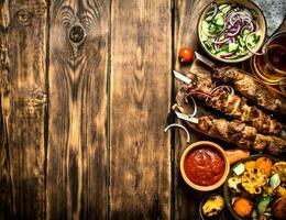 Kebab with tomato sauce and roasted vegetables. photo